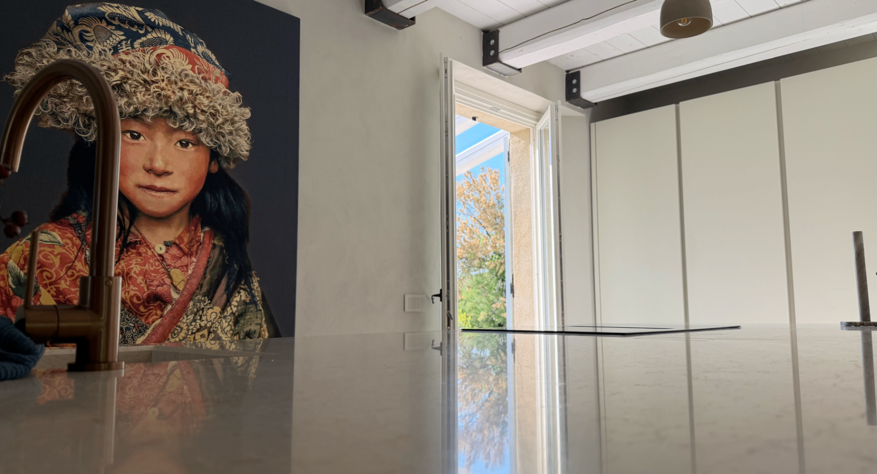Kitchen view with stone walls, artwork and open doors to the garden