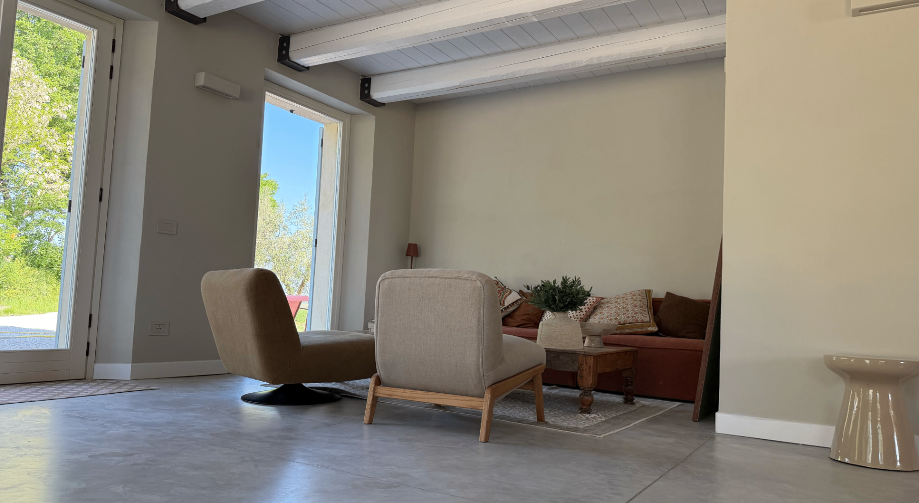 Calm living room with white beams, soft seating and garden light