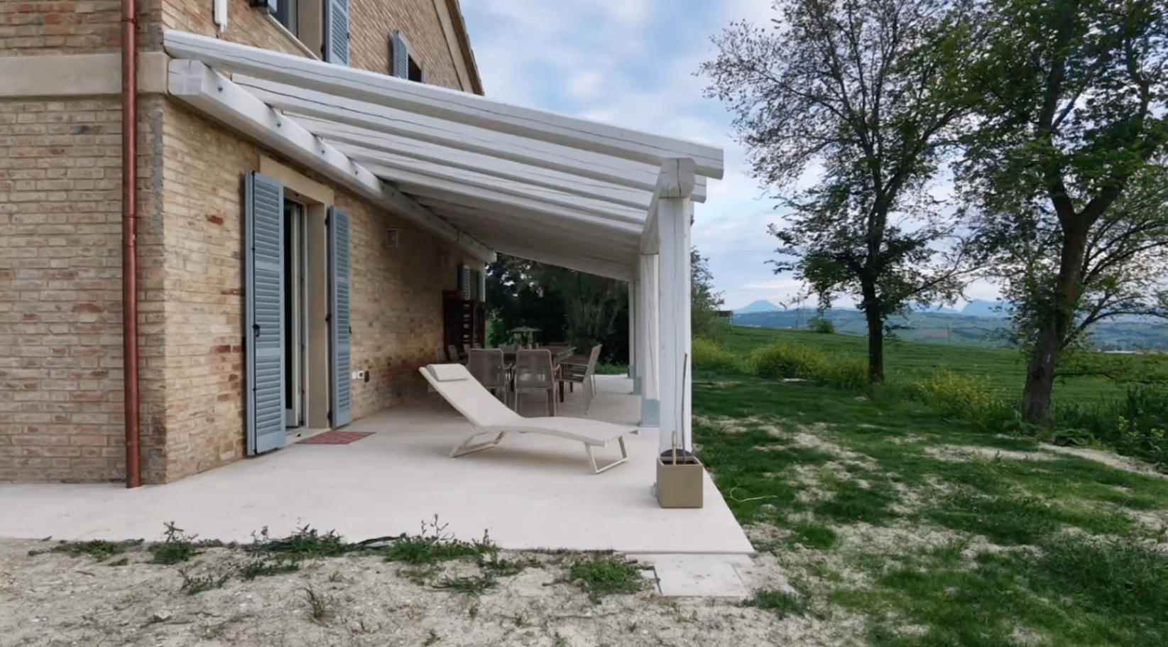 Covered terrace beside the villa with loungers and open countryside